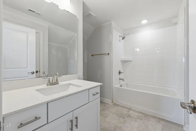 a bathroom with a bathtub shower sink vanity and a mirror