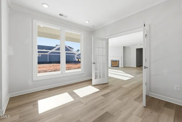 an empty room with wooden floor and a fireplace