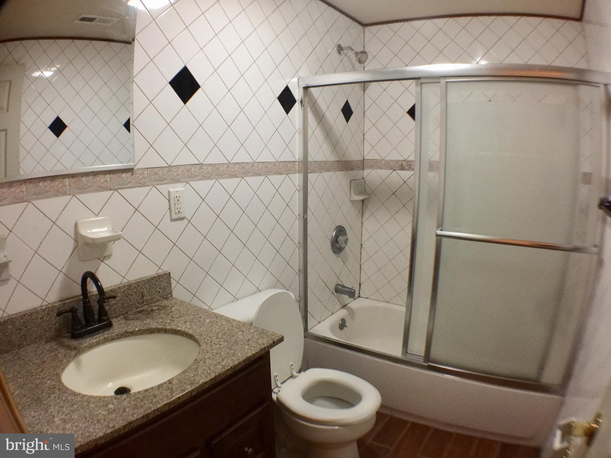 1241 Vine Street, Unit 2R Philadelphia, PA 19107 - Photo 5 of 7 a bathroom with a granite countertop sink toilet and shower