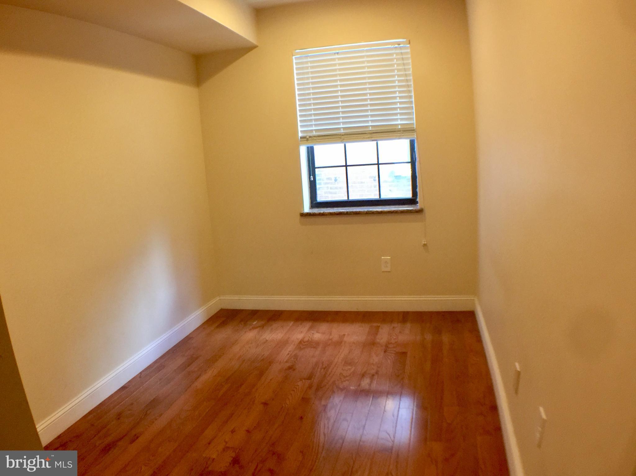 1241 Vine Street, Unit 2R Philadelphia, PA 19107 - Photo 6 of 7 an empty room with wooden floor and windows