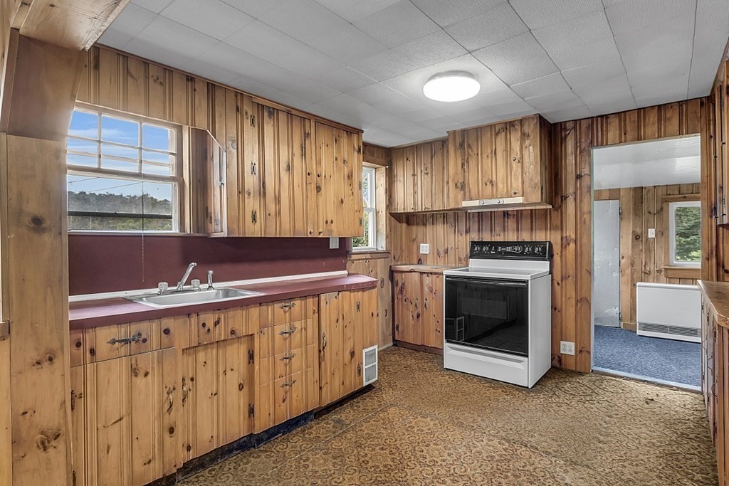 369 Old Northfield Road Ashby, MA 01431 - Photo 6 of 24 a kitchen with sink a stove and white cabinets