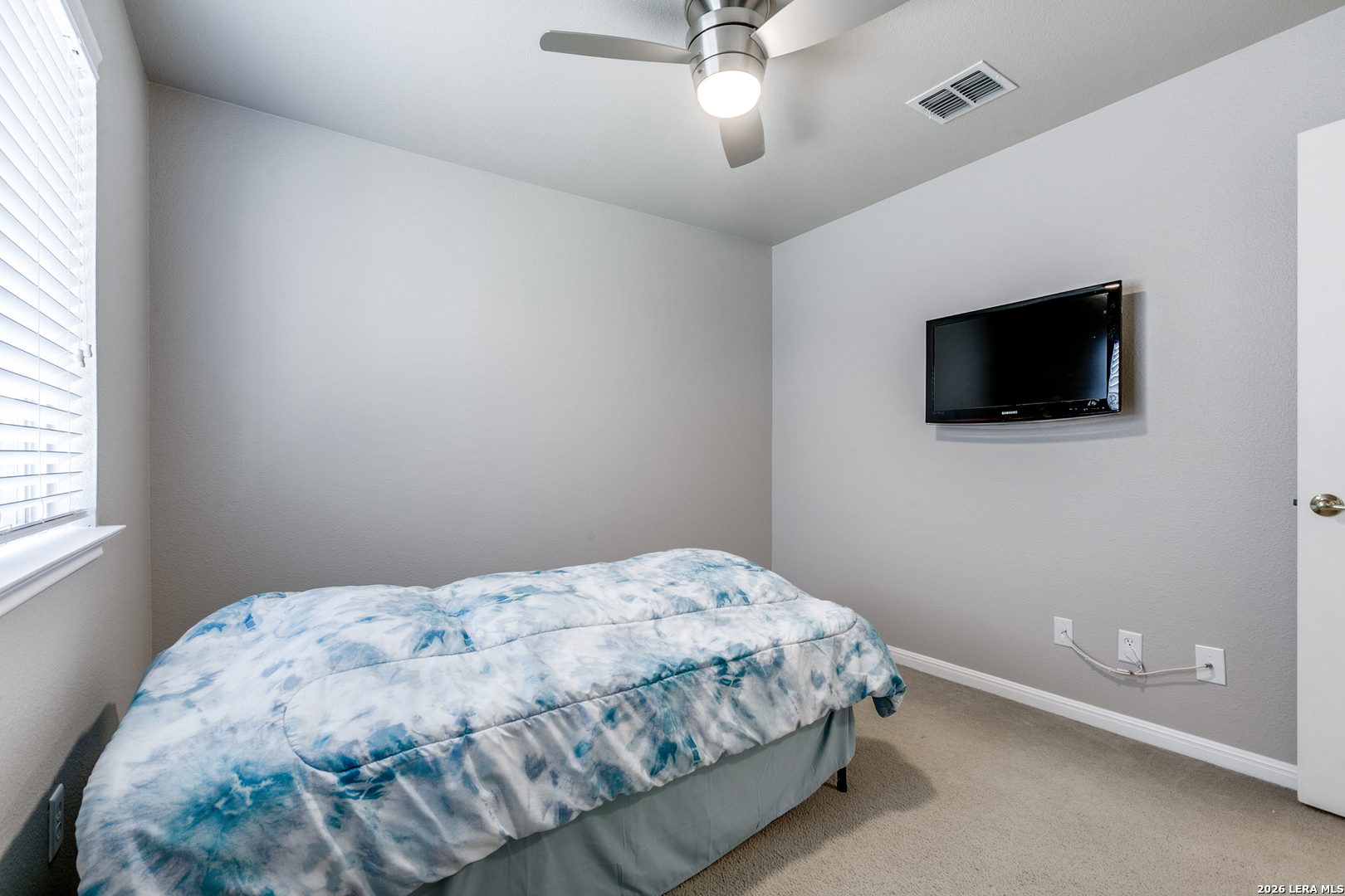 6822 Freedom Ridge San Antonio, TX 78242 - Photo 19 of 25 a bedroom with a bed and a flat screen tv