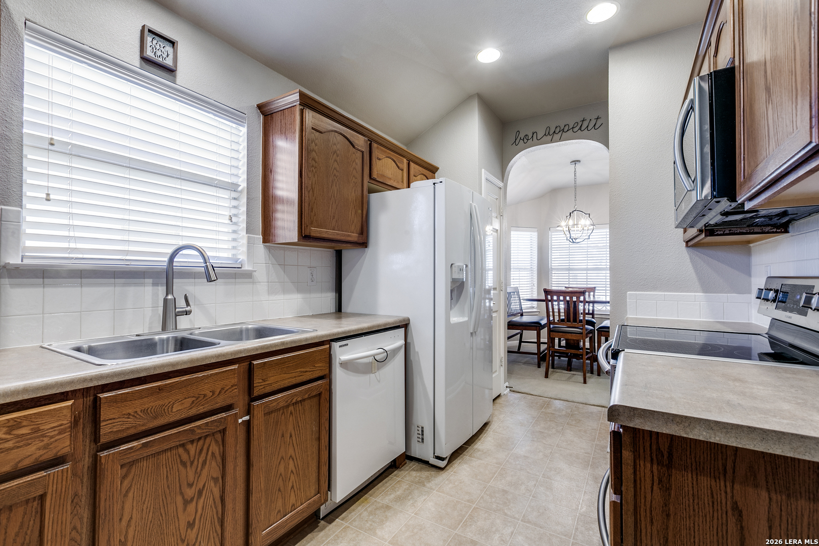 6822 Freedom Ridge San Antonio, TX 78242 - Photo 10 of 25 a kitchen with stainless steel appliances sink a microwave and cabinets