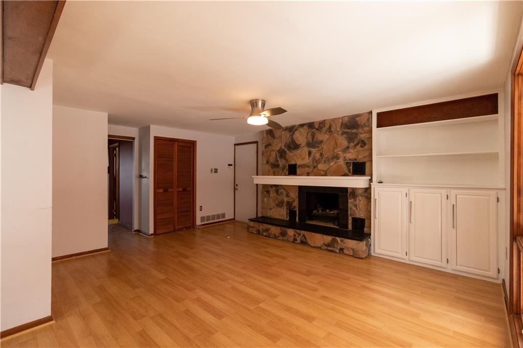 3380 Ridgway Street Pittsburgh, PA 15213 - Photo 5 of 25 Full view of the family room with gas fireplace as seen from the kitchen and/or sunroom doorway. White door at the back opens onto the house's main entryway. The additional room (with wet bar and second office) is through the door on the left.