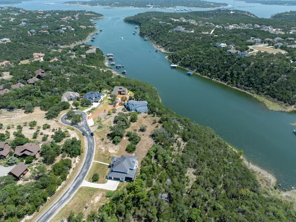 an aerial view of a house with a yard and lake view