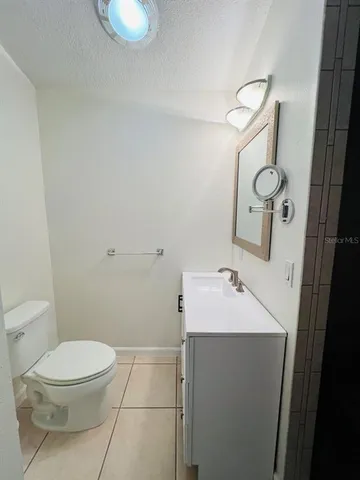 a bathroom with a sink toilet and mirror