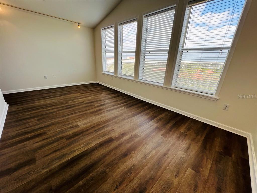 101 Palm Harbor Parkway, Unit A404 Palm Coast, FL 32137 - Photo 15 of 16 a view of an empty room with wooden floor and a window