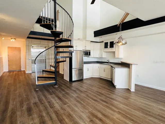 a view of a kitchen with wooden floor and electronic appliances