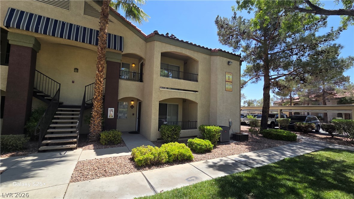 7885 West Flamingo Road, Unit 1008 Las Vegas, NV 89147 - Photo 12 of 29 Mediterranean-inspired architecture graces this multi-level residential building, surrounded by mature trees and verdant landscaping.