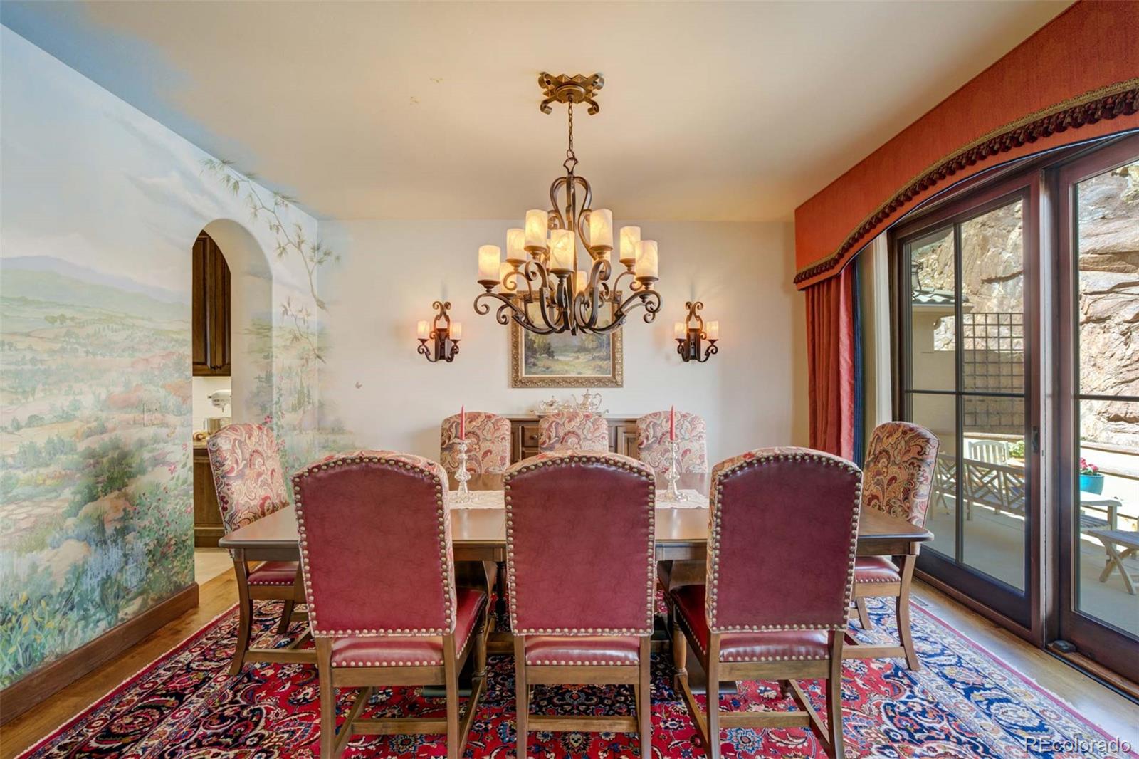 14250 Aiken Ride View Colorado Springs, CO 80926 - Photo 14 of 50 a dining room with furniture a chandelier and wooden floor