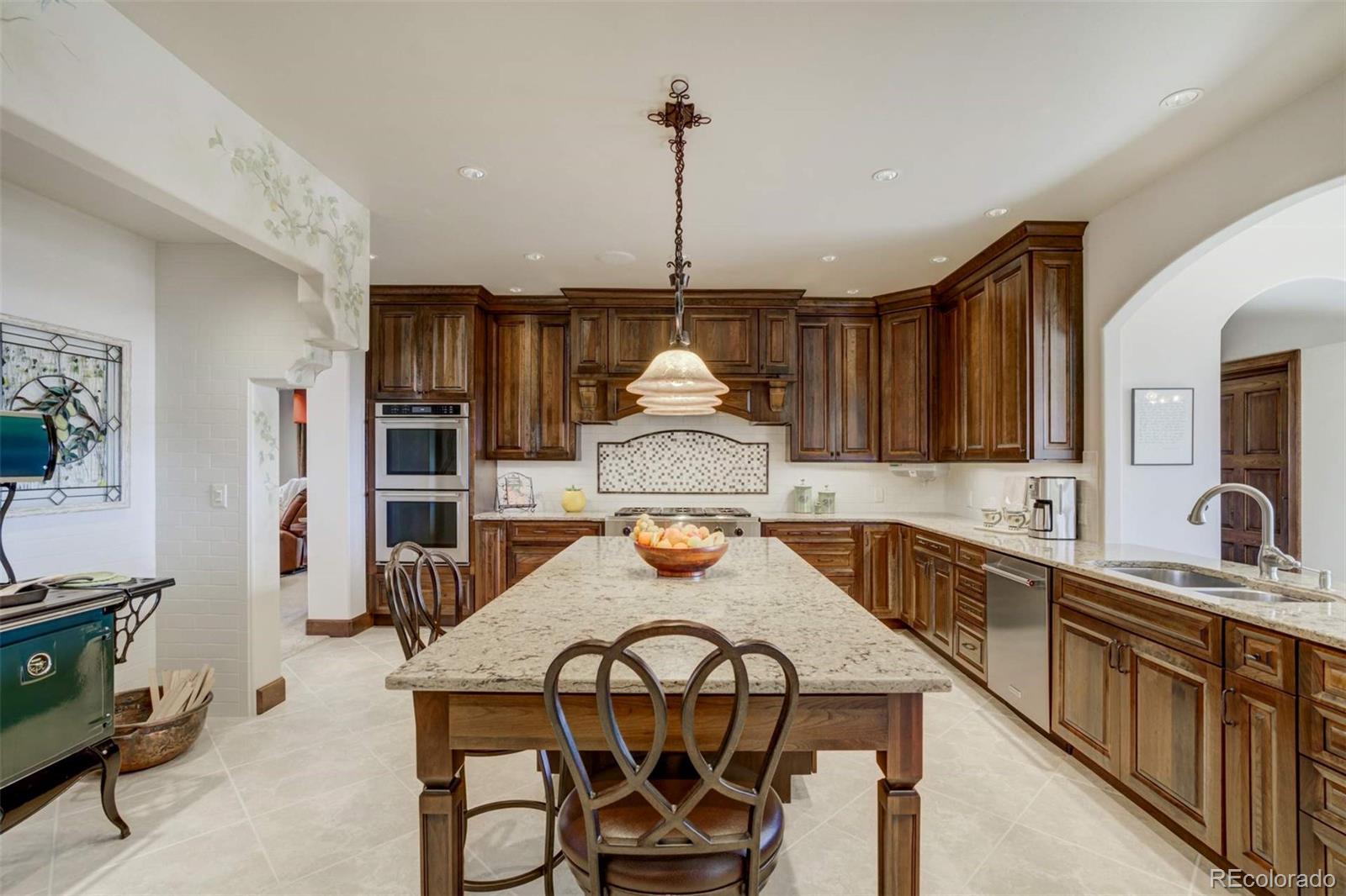 14250 Aiken Ride View Colorado Springs, CO 80926 - Photo 17 of 50 a kitchen with stainless steel appliances a dining table and chairs