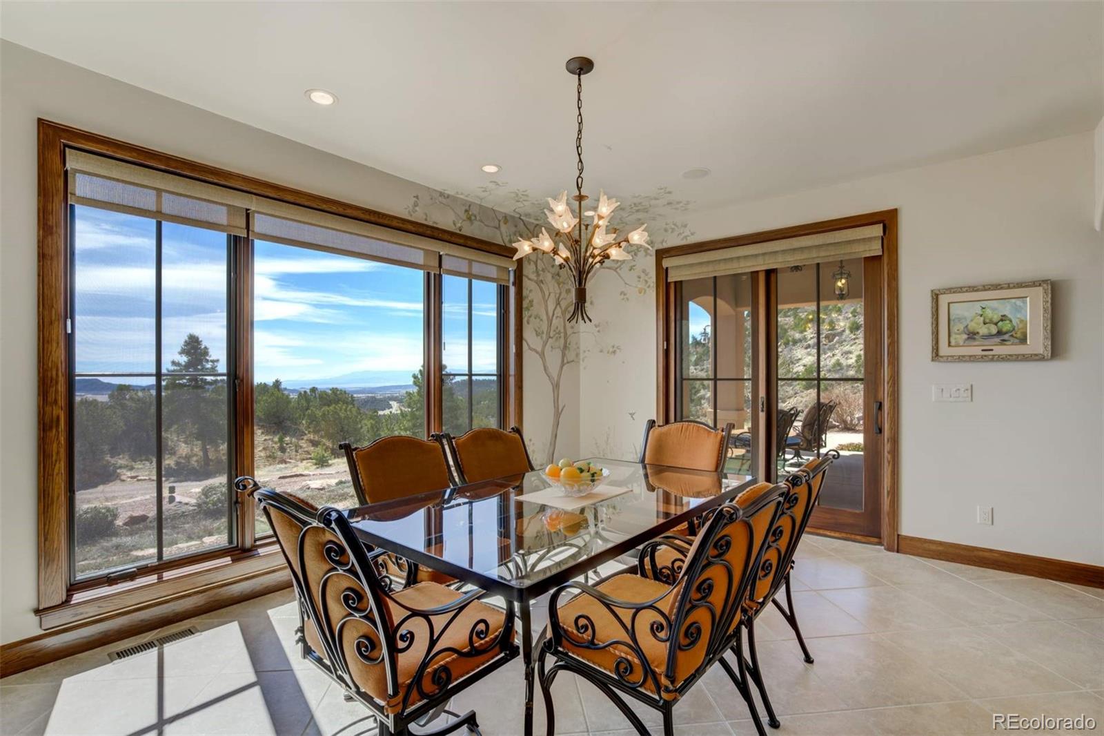 14250 Aiken Ride View Colorado Springs, CO 80926 - Photo 24 of 50 a dining room with furniture large windows and a chandelier