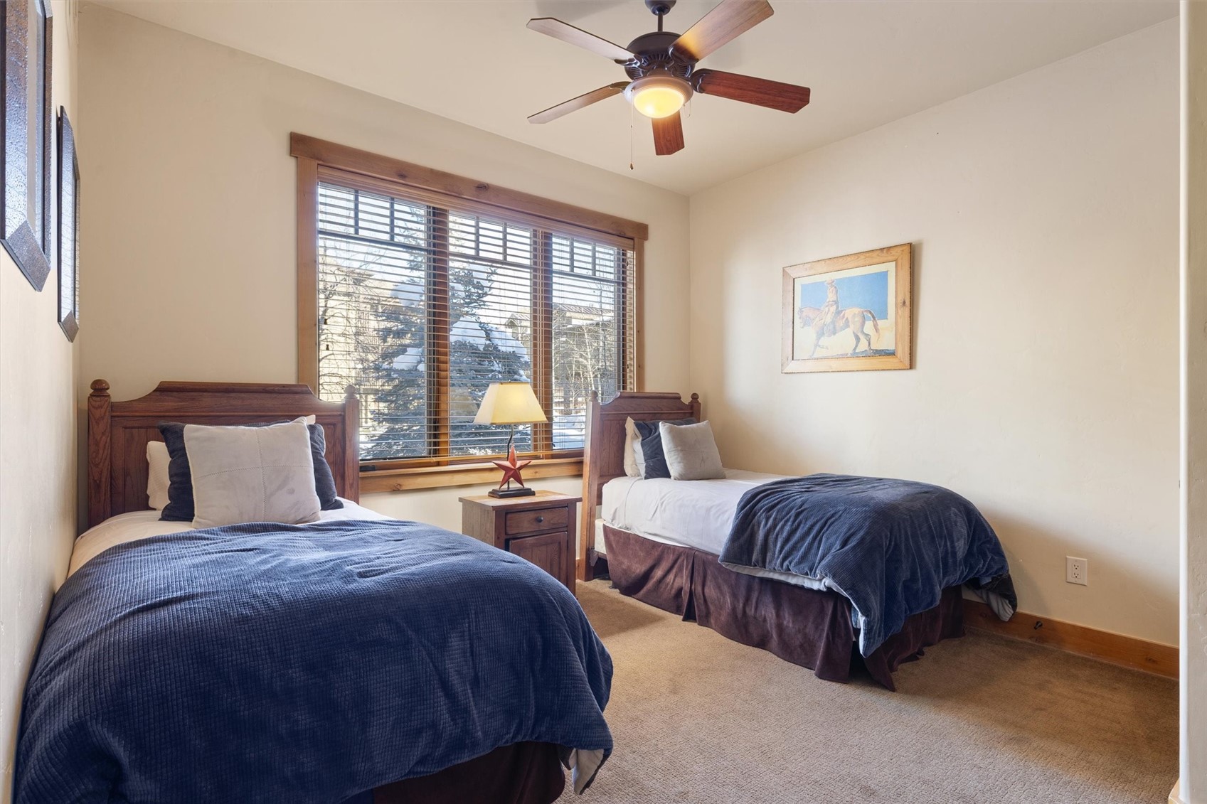 1750 Medicine Springs Road, Unit 6105 Steamboat Springs, CO 80487 - Photo 15 of 43 a bedroom with two beds and a chandelier