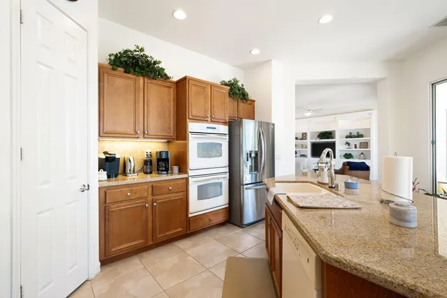 a kitchen with granite countertop a sink and wooden cabinets