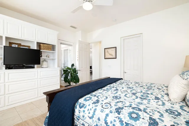 a bedroom with a bed and a lamp on dresser