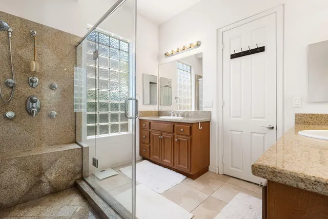 a bathroom with a granite countertop sink toilet and shower