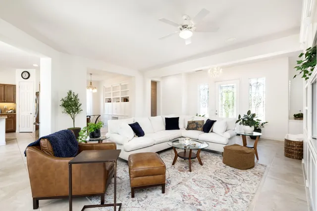 a living room with furniture and potted plants