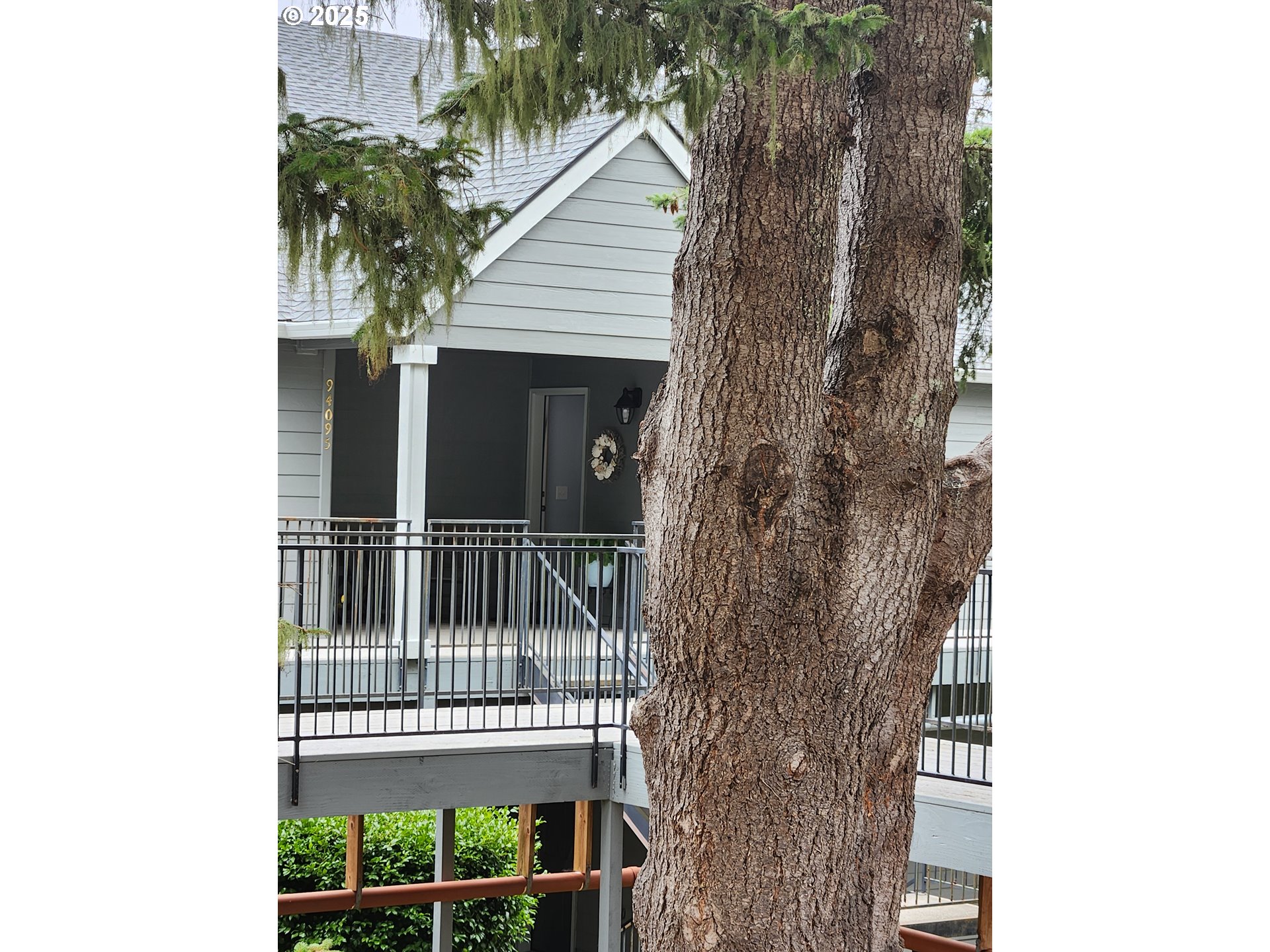a view of a house with a small yard and potted plants
