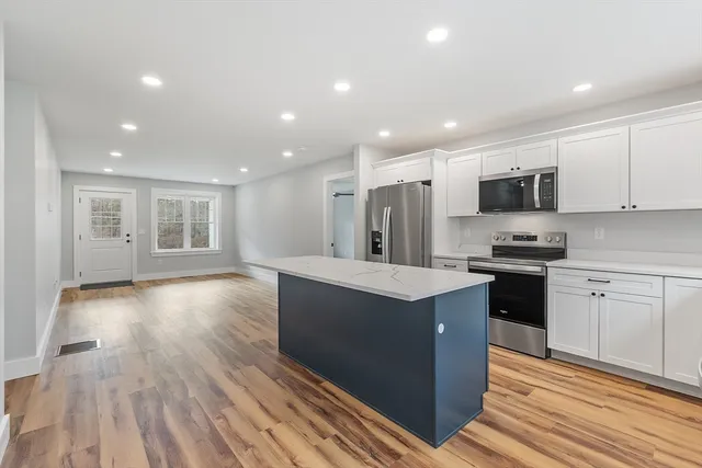 a kitchen with granite countertop a stove top oven and cabinets