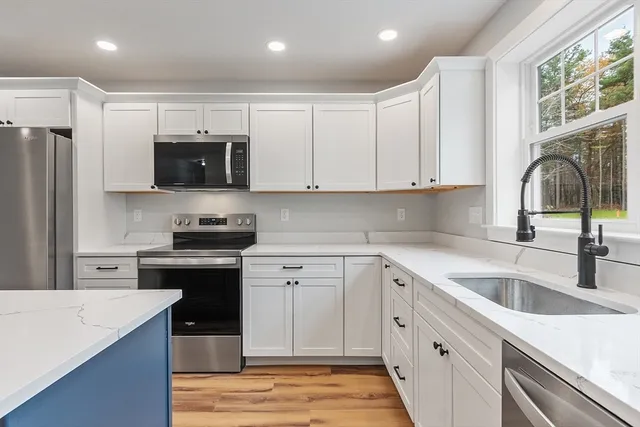 a kitchen with stainless steel appliances granite countertop a sink stove and refrigerator