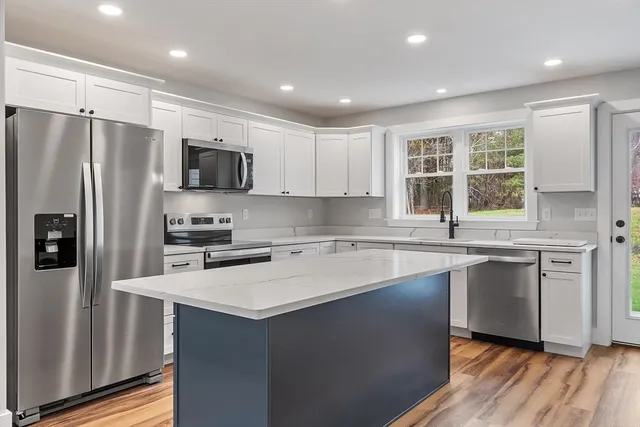 a kitchen with stainless steel appliances a refrigerator stove microwave and sink