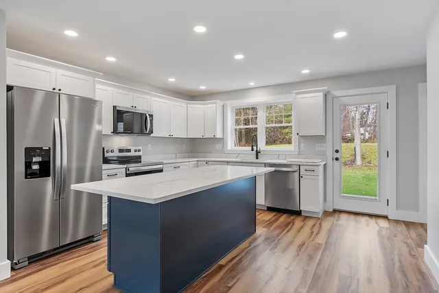 a kitchen with a sink a counter top space stainless steel appliances and cabinets