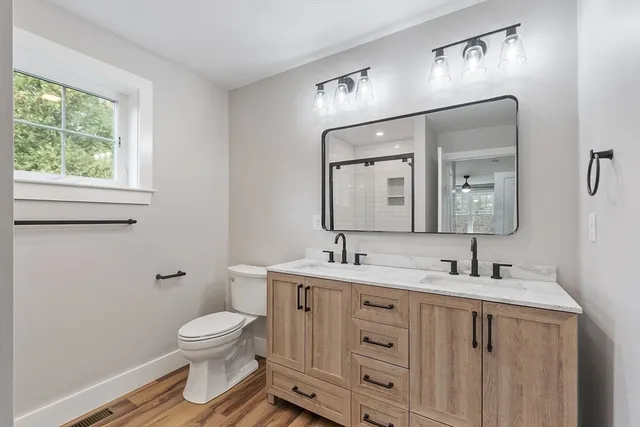 a bathroom with a toilet sink and mirror