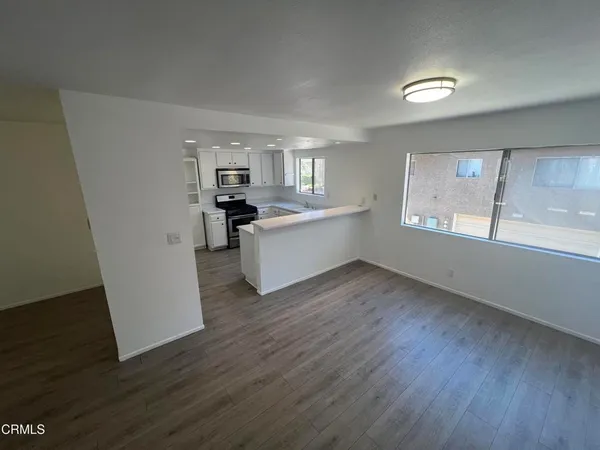 a view of a kitchen with wooden floor and electronic appliances