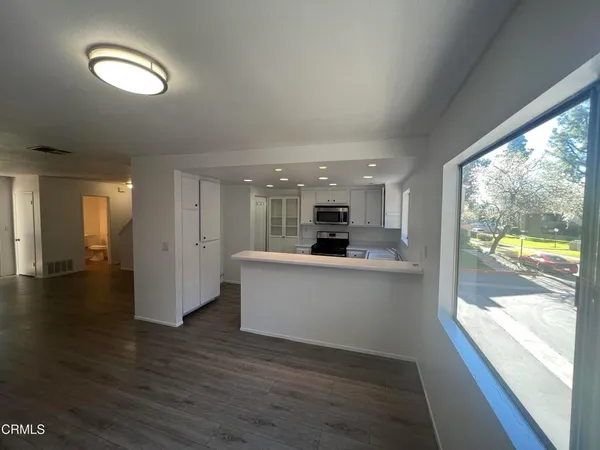 a view of open kitchen with wooden floor and outdoor space