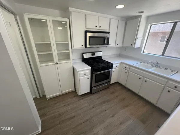 a kitchen with sink a microwave and a refrigerator