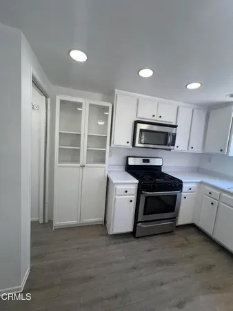 a kitchen with granite countertop a stove a sink and a refrigerator