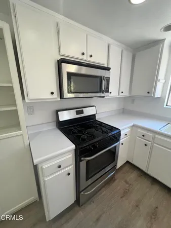 a white stove top oven sitting inside of a kitchen