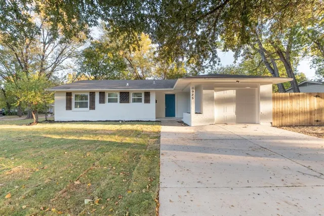 a front view of a house with a yard and trees