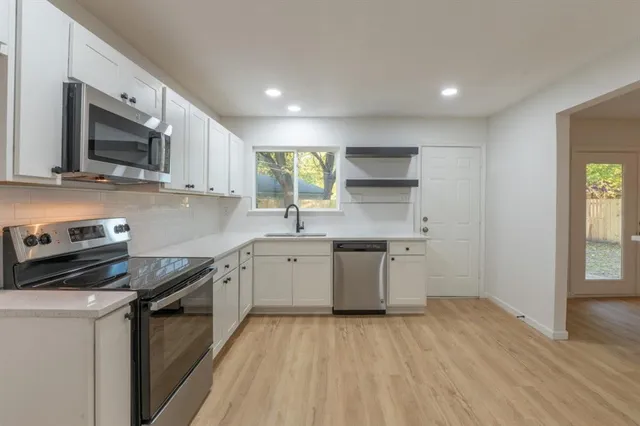 a kitchen with a sink stove top oven and microwave