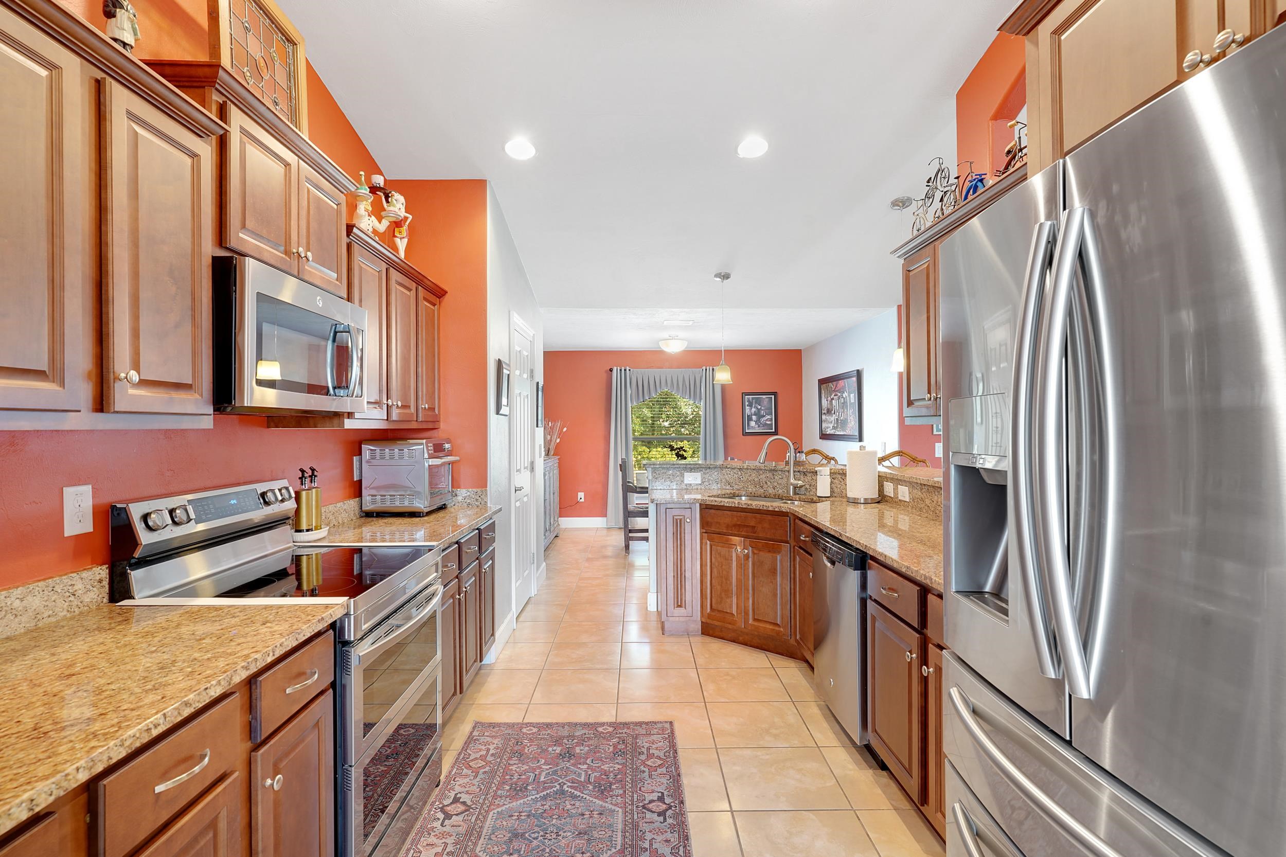 121 Harrison Road Daytona Beach, FL 32118 - Photo 14 of 48 a kitchen with stainless steel appliances granite countertop a refrigerator a stove top oven and sink