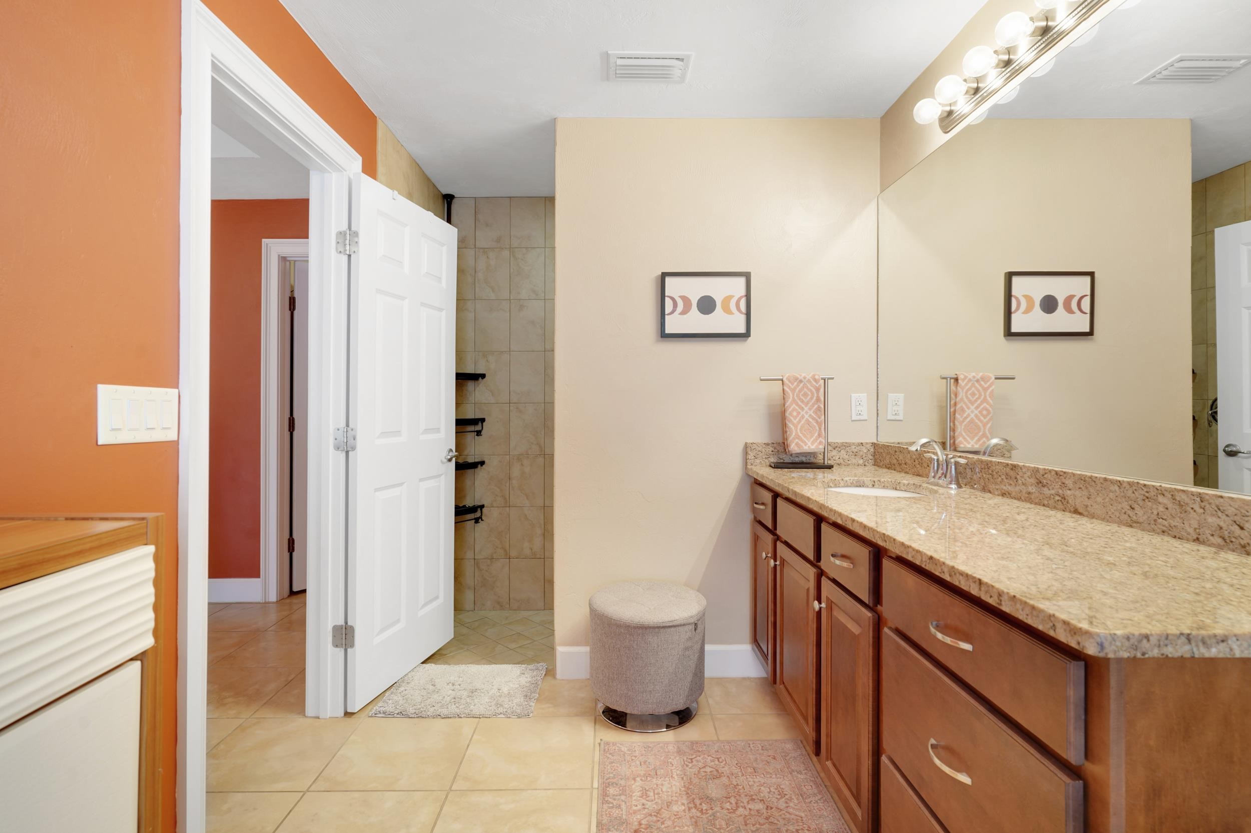 121 Harrison Road Daytona Beach, FL 32118 - Photo 23 of 48 a bathroom with a granite countertop sink a toilet a mirror and shower