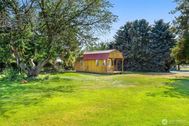 a front view of a house with a yard and trees