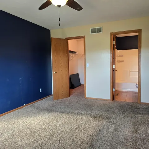 a view of an empty room with a ceiling fan