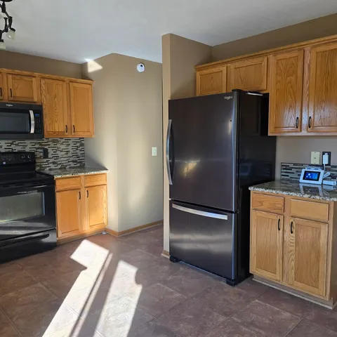 a kitchen with stainless steel appliances granite countertop a refrigerator and a stove