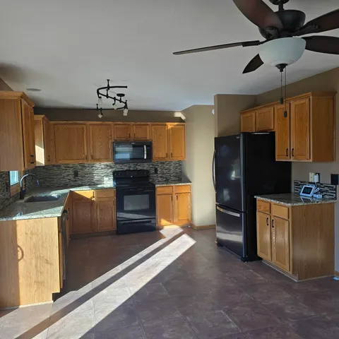 a kitchen with stainless steel appliances granite countertop a stove refrigerator and cabinets