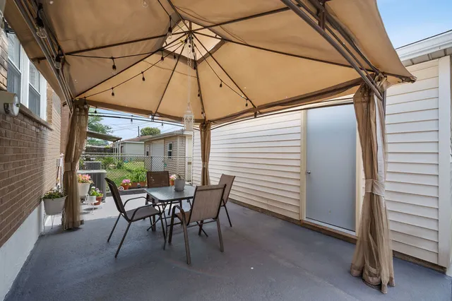 a view of a patio with a table and chairs under an umbrella