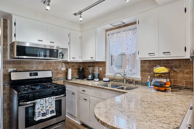 a kitchen with stainless steel appliances a stove a sink a stove and cabinets