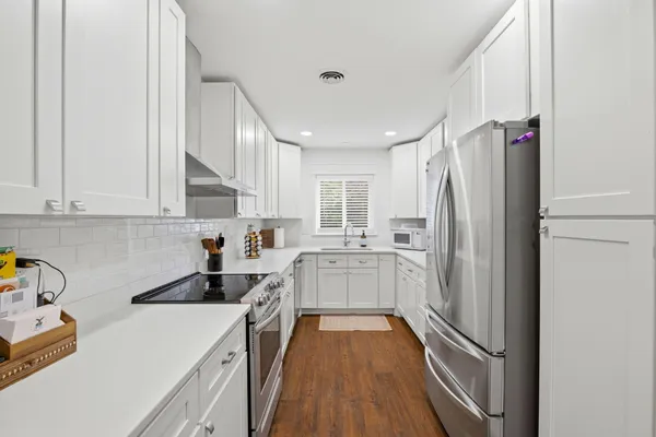 a kitchen with a refrigerator a sink and cabinets