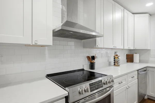 a kitchen with granite countertop white cabinets and white appliances