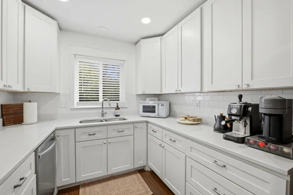 a kitchen with stainless steel appliances granite countertop white cabinets sink and a granite counter tops