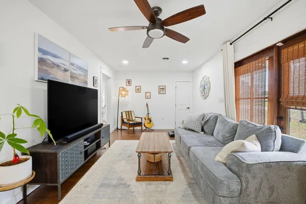 a living room with furniture a flat screen tv and a window