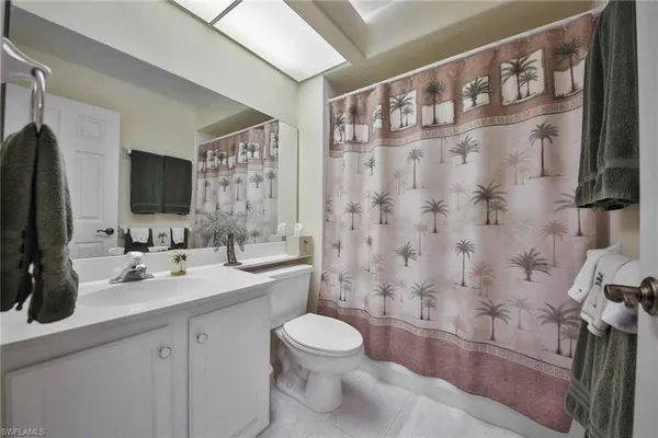 a bathroom with a toilet sink a mirror a shower and vanity