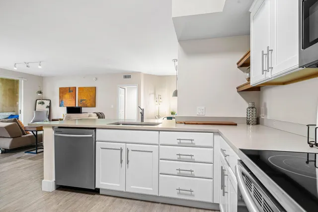 a kitchen with a sink a stove top oven and white kitchen