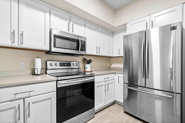 a kitchen with stainless steel appliances granite countertop a refrigerator stove a sink and a microwave