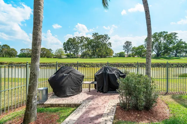 a view of a swimming pool with lawn chairs under an umbrella